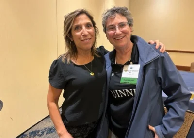 Oregon Geriatrics Society 2023 Conference - two attendees pose for a photo in a room with pale yellow walls and patterned carpet