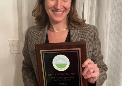 Oregon Geriatrics Society 2025 Conference - Emily Morgan, M.D. poses with a plaque in honor of her leadership as OGS's Education Committee Chair (2020-2025)