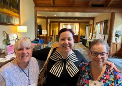 Oregon Geriatrics Society 2025 Conference - three attendees pose for a photo op in the lobby near the registration table